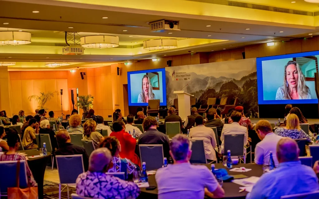 Conference session with remote keynote speakers on twin screens addressing an ALI-East Africa audience.